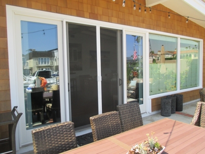 Patio access with white sliding glass doors and dark gray screens.