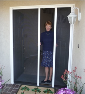 Woman in front of white sliding screen door.